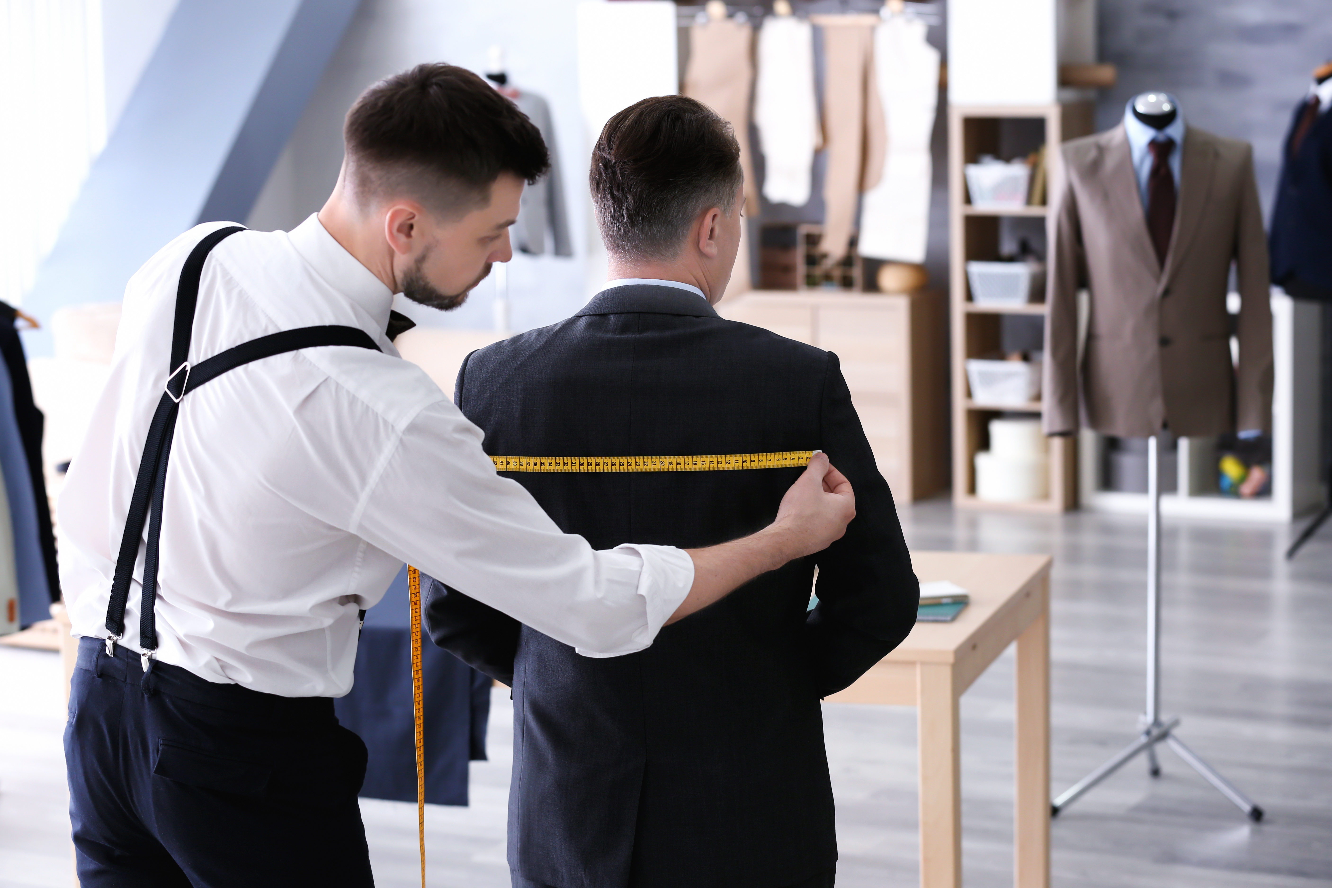 Tailor measuring a suit jacket in the studio
